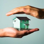 ミニチュアの家を手に持っている人