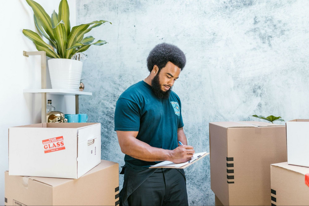 a man standing in front of boxes holding a clipboard