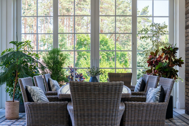 a room with wicker furniture and a large window